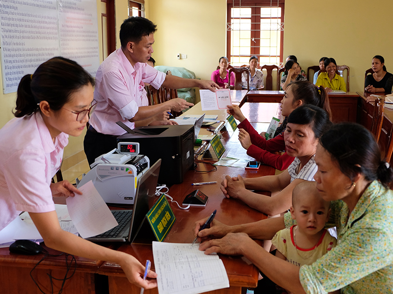 Cán bộ NHCSXH huyện Cô Tô hướng dẫn người dân thực hiện các thủ tục va vốn tại xã Đồng Tiến