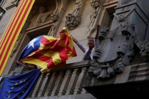 Một người biểu tình đem cờ ly khai lên ban công tòa nhà Bộ kinh tế của Catalonia. (ảnh: Reuters)