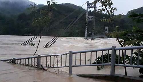 Cây cầu treo ở xã Xuân Cẩm, huyện Thường Xuân cũng bị lũ đe doạ quật đổ. Ảnh: Thái Sơn.