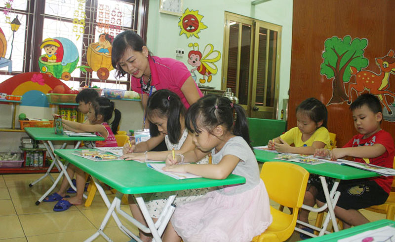 Cô giáo Nguyễn Thị Nam hướng dẫn học lớp 5 tuổi trong giờ hoạt động tạo hình.