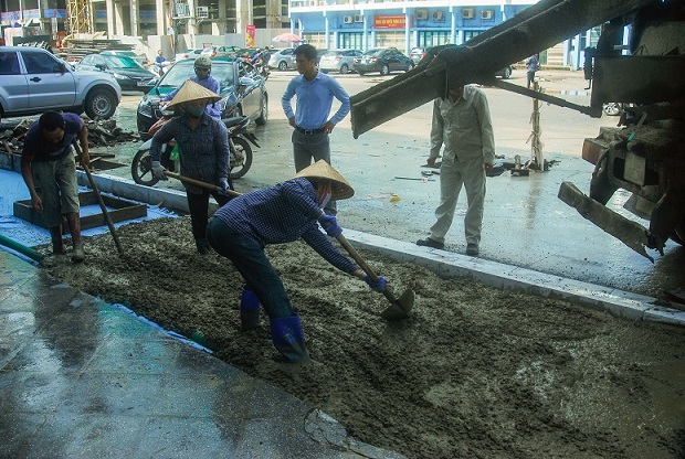 Công nhân đổ bê tông vỉa hè sau khi hoàn thành hạ ngầm đường dây điện, cáp viễn thông... 