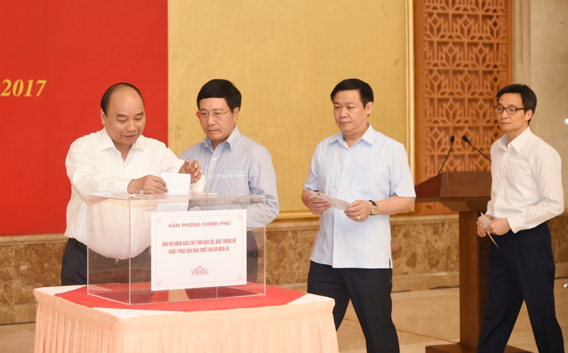 Thủ tướng Nguyễn Xuân Phúc và các Phó Thủ tướng quyên góp ủng hộ đồng bào bị ảnh hưởng lũ lụt. Ảnh: VGP/Quang Hiếu