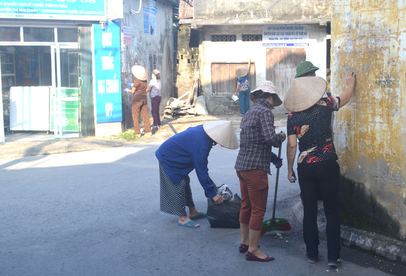 Các hội viên Hội Nông dân phường Cẩm Bình xóa quảng cáo bẩn ở đường Cẩm Bình  