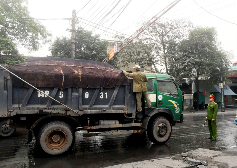 Lực lượng chức năng kiểm tra xe chở than tại chốt Vĩnh Phú, phường Mạo Khê ra QL18 (Ảnh: Nguyễn Xuân). 