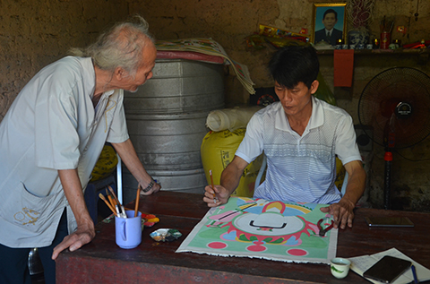 Nghệ nhân Hà Văn Tài đang vẽ tranh.