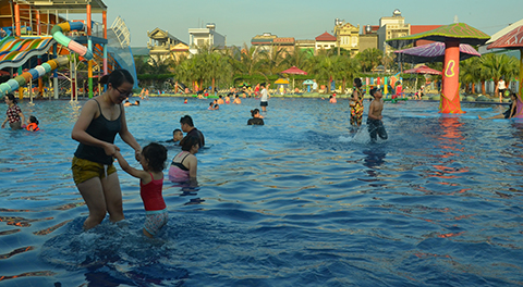 Phụ huynh nên cho con em mình làm quen với nước và tập bơi ngay từ rất nhỏ. (Trong ảnh: Công viên nước Hà Lan, phường Mạo Khê, TX Đông Triều). 