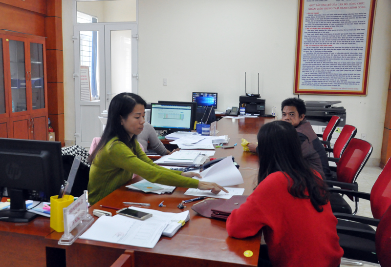 Cán bộ Trung tâm Hành chính công huyện Bình Liêu hướng dẫn người dân làm thủ tục. 