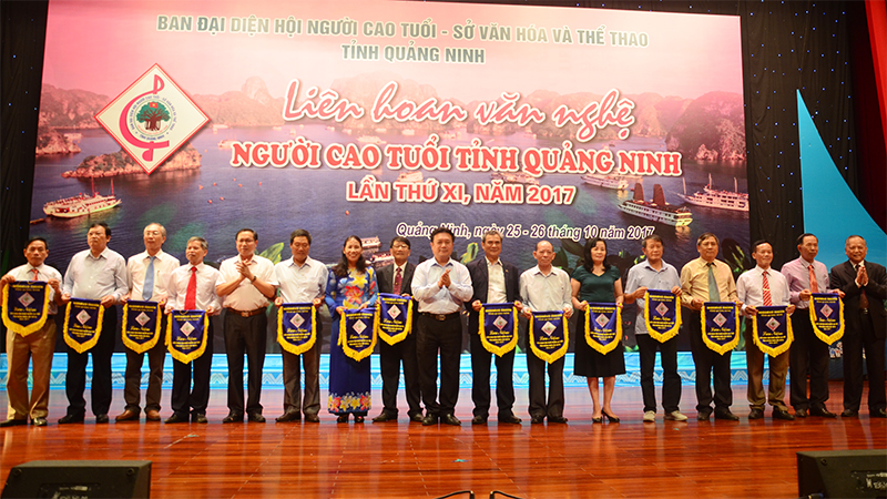 Đồng chí Nguyễn Đức Thành, Phó Chủ tịch HĐND tỉnh, và lãnh đạo Sở Văn hóa- Thể thao, Hội Người Cao tuổi Quảng Ninh trao cờ lưu niệm cho đại diện các đoàn tham gia liên hoan.