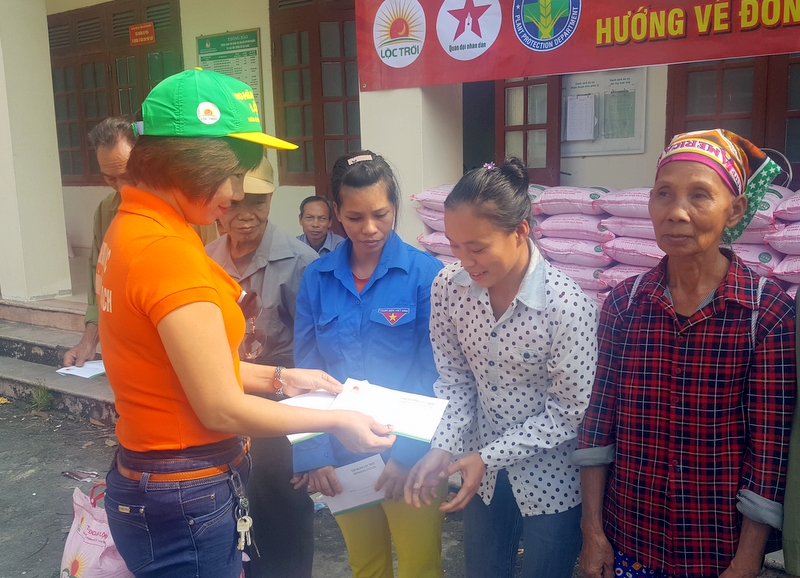 Cán bộ xã Đồng Lâm và thành viên của Đoàn từ thiện Tập đoàn Lộc Trời tặng gạo và quà cho các hộ nghèo trên địa bàn xã Đồng Lâm.