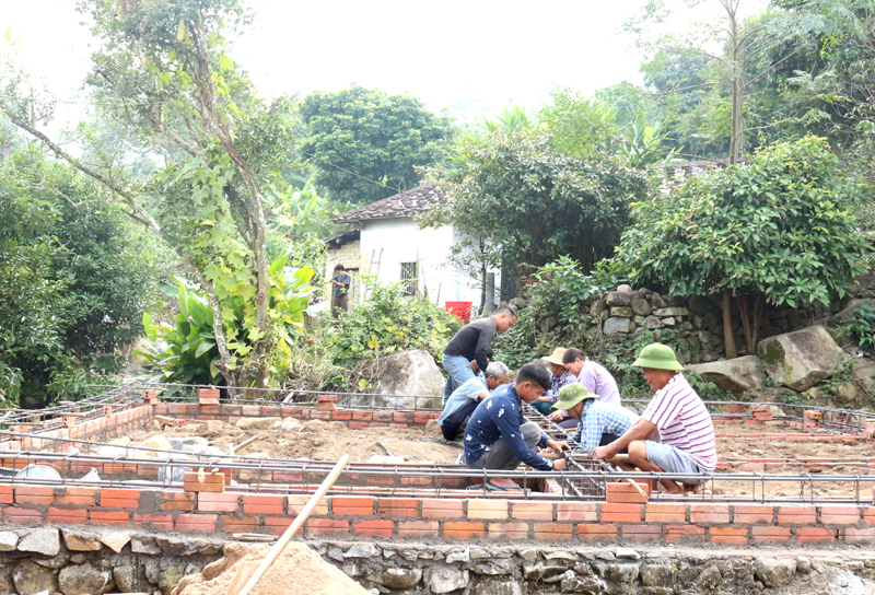 Người dân thôn Nặm Tút, xã Lục Hồn giúp đỡ gia đình ông Đặng Văn Mản buộc sắt chuẩn bị giằng móng xây nhà.
