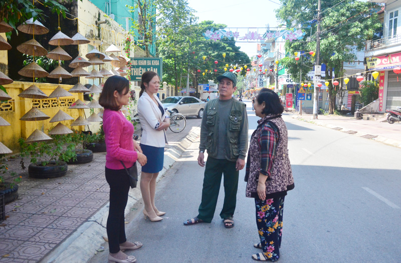 Cán bộ thị trấn trao đổi với nhân dân khu phố Lý Thường Kiệt về tăng cường giữ gìn vệ sinh môi trường.