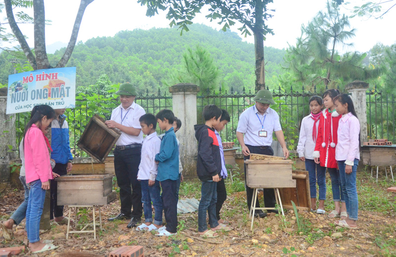 Các thầy giáo trường Phổ thông Dân tộc bán trú tiểu học và THCS Đồn Đạc hướng dẫn học sinh kỹ thuật nuôi ong lấy mật