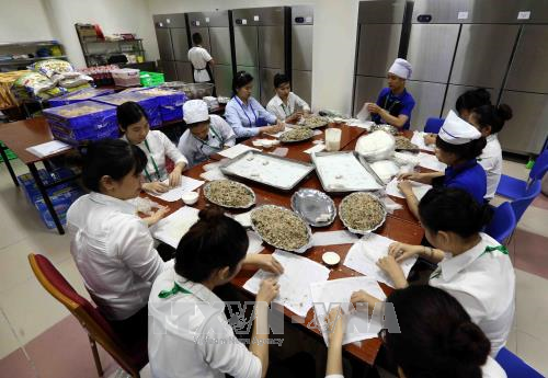 Nhân viên chuẩn bị các món ăn ẩm thực phục vụ phóng viên trong nước, quốc tế tại Trung tâm báo chí Quốc tế. Ảnh: TTXVN