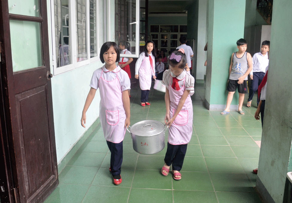 Một nhóm tự quản của học sinh Trường Tiểu học Hà Lầm (TP Hạ Long) đang bê thức ăn lên lớp
