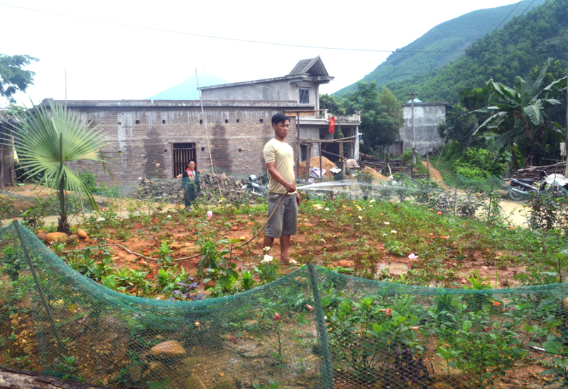 Dù rất bận làm nhà mới, nhưng anh Chìu Chăn Giếng, thôn Khe Mằn, xã Đồn Đạc vẫn tranh thủ chăm sóc vườn hoa của thôn