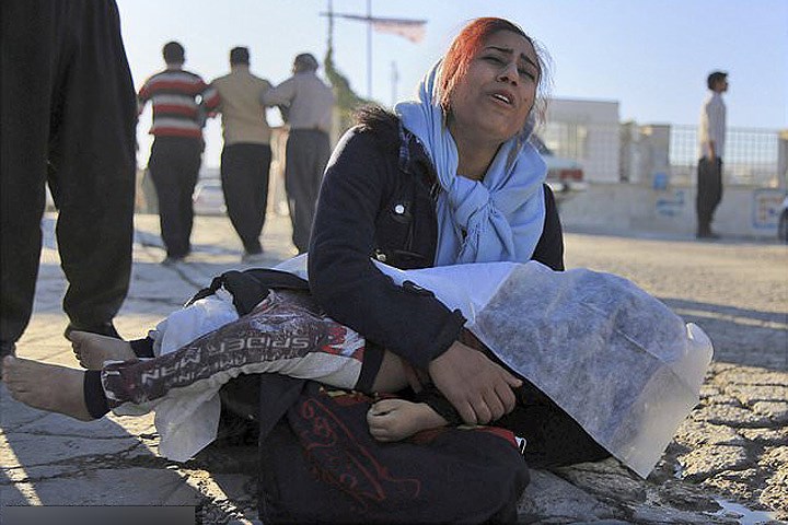 Người mẹ ôm đứa con gái của mình. Cháu bé tử vong trong trận động đất 13/11. Ảnh: Thông tấn Iran.