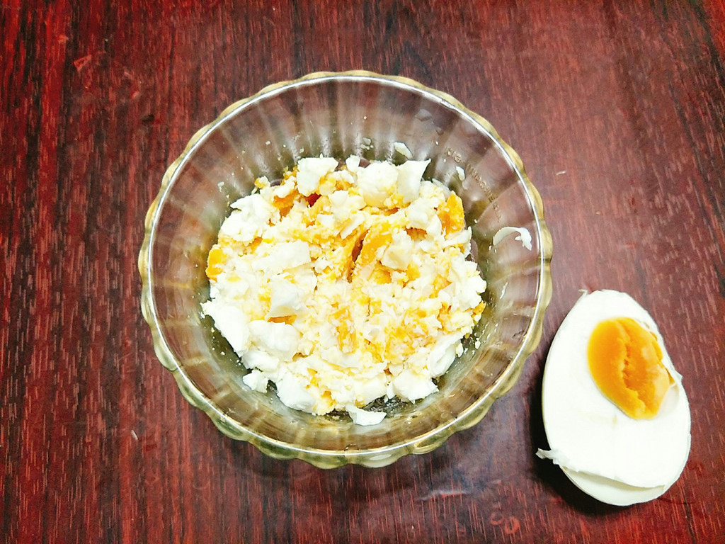 Trứng muối bổ làm đôi rồi dùng thìa lấy trứng ra bát, dằm cho nhuyễn. Tỏi băm nhỏ.