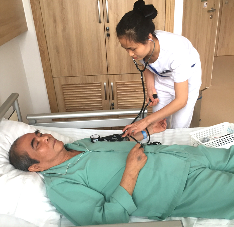 Nữ điều dưỡng Phạm Thu Trang đang đo huyết áp cho bệnh nhân tại Bệnh viện Đa khoa Quốc tế Vinmec Hạ Long.