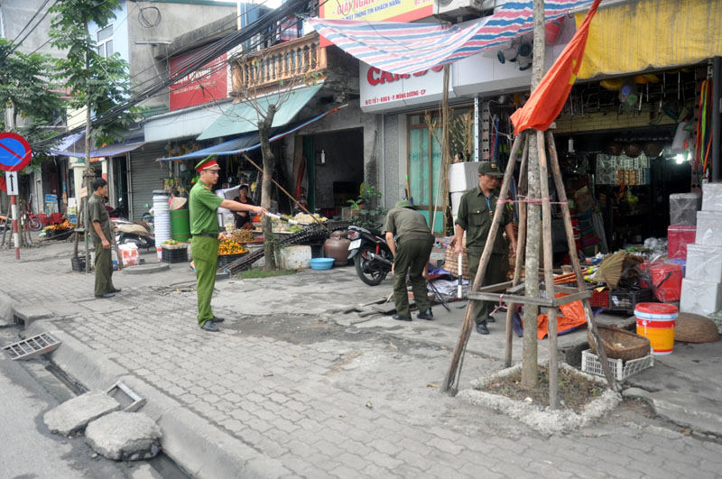 Cán bộ, chiến sĩ Công an phường Mông Dương chủ động duy trì trật tự an toàn giao thông ở khu vực cổng chợ trung tâm của phường 
