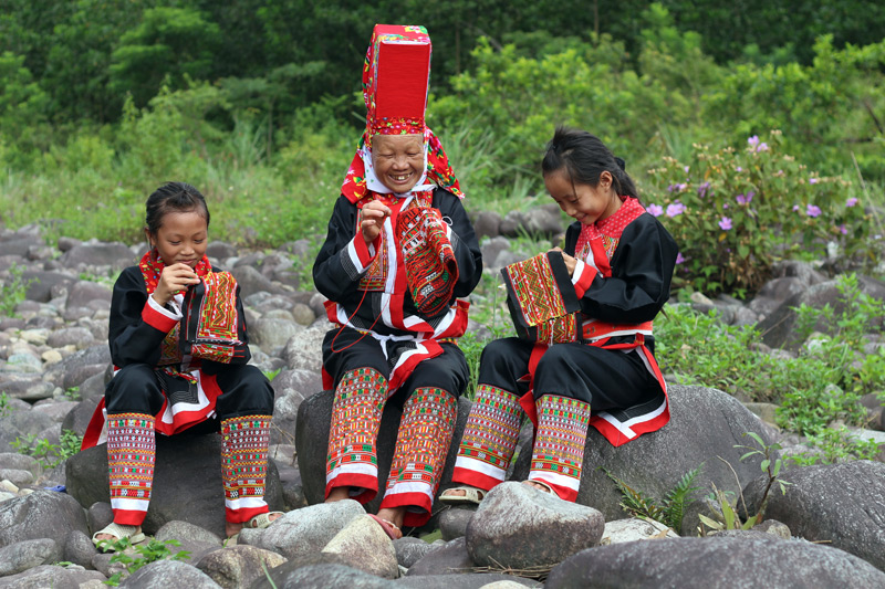 Nghệ nhân Giềng Chống Sếnh hướng dẫn cho thế hệ trẻ xã Quảng Sơn nghệ thuật thêu thùa trang phục dân tộc Dao.