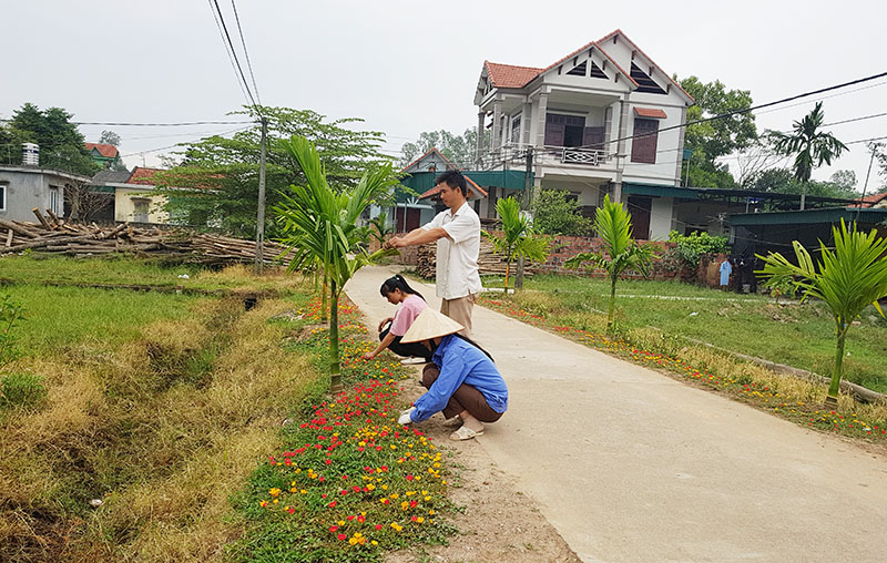 Người dân thôn Giếng Sen, xã Tiền An (TX Quảng Yên) chăm sóc hoa và cây cảnh trên tuyến đường thôn.