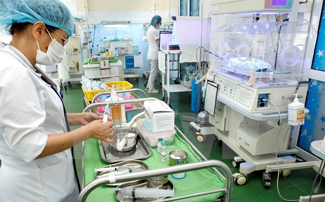 Nhân viên y tế thực hiện việc chăm sóc cho trẻ sơ sinh. (Ảnh: Dương Ngọc/TTXVN)
