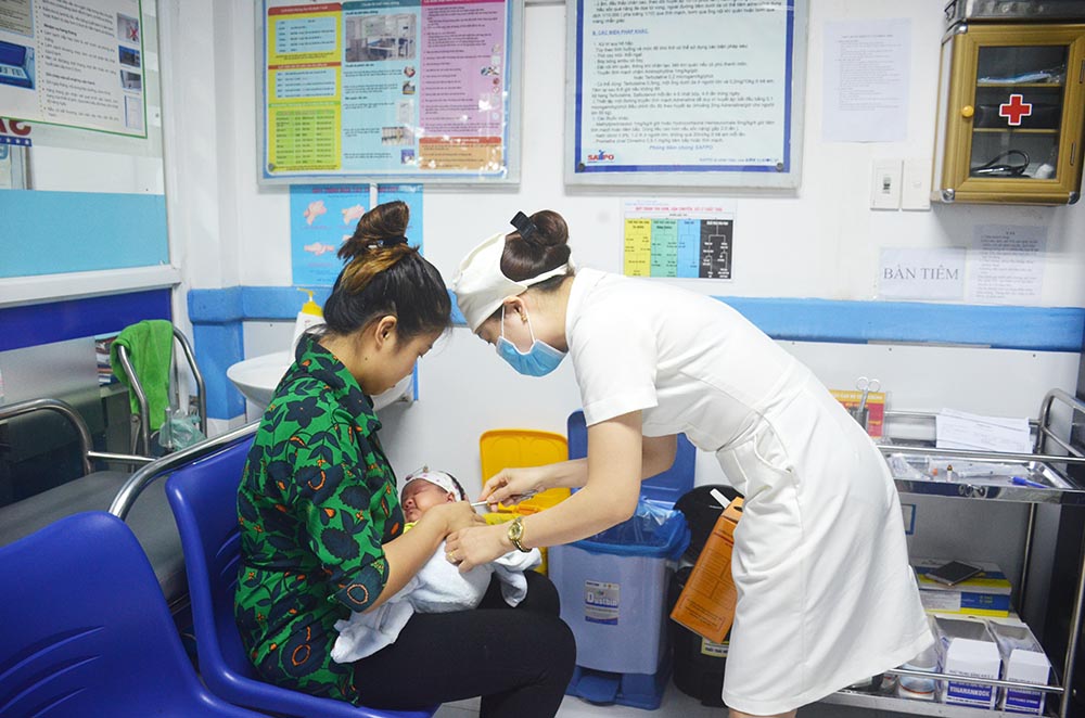 Nhân viên y tế Trung tâm Y tế dự phòng tỉnh tiêm phòng cho trẻ