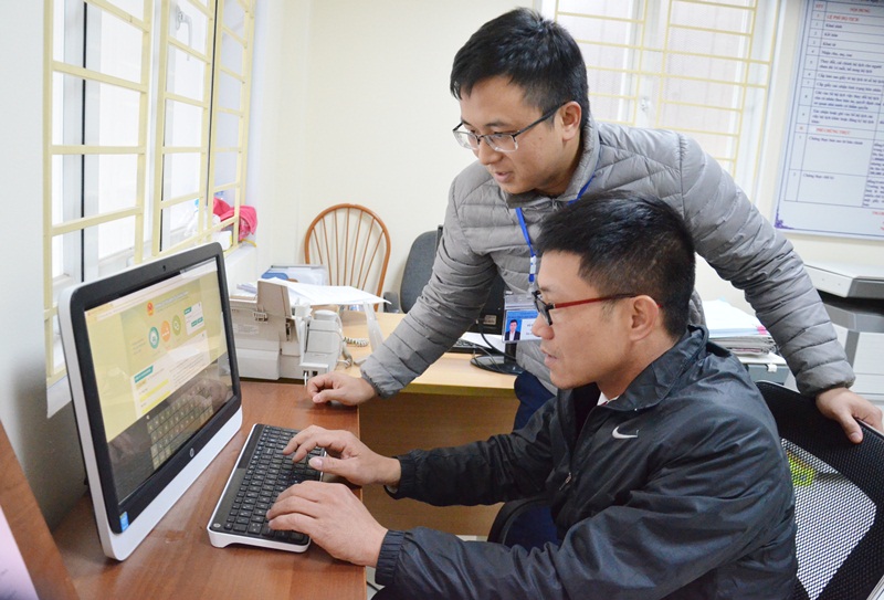 Cán bộ Bộ phận tiếp nhận và trả kết quả hiện đại phường Hồng Gai (TP Hạ Long) hướng dẫn người dân đánh giá ý kiến qua mạng.