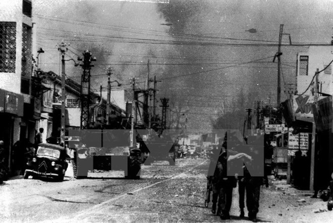 Lính Mỹ khiêng xác đồng bọn (bên phải) bị lực lượng vũ trang cách mạng tiêu diệt trên đường phố Sài Gòn. (Ảnh: Tư liệu TTXGP)