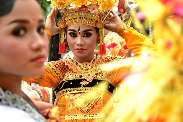  Một cô gái chỉnh trang phục trước khi biểu diễn điệu nhảy truyền thống trong lễ hội đón năm mới ở Denpasar, Indonesia. Ảnh: The Sun. 