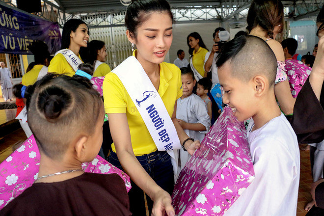 Các thí sinh hoa hậu trao quà cho các em nhỏ mồ côi tại chùa Thanh Sơn. Ảnh: An Bình.