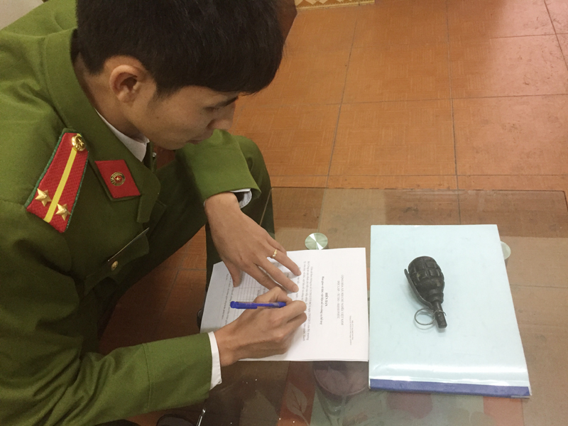 Cán bộ Công an phường Mạo Khê (TX Đông Triều) làm thủ tục tiếp nhận quả lựu đạn. 