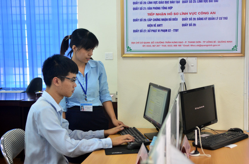 Cán bộ TT HCC Uông Bí hướng dẫn người dân thực hiện dịch vụ công trực tuyến