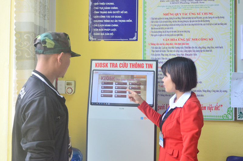 Công chức phường Thanh Sơn, TP Uông Bí hướng dẫn người dân tra cứu thông tin giải quyết thủ tục hành chính. Ảnh: Nguyễn Dung