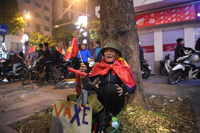 Ông cụ vá xe nở nụ cười trong đêm ăn mừng của bóng đá Việt Nam. Ảnh: Trọng Hải.