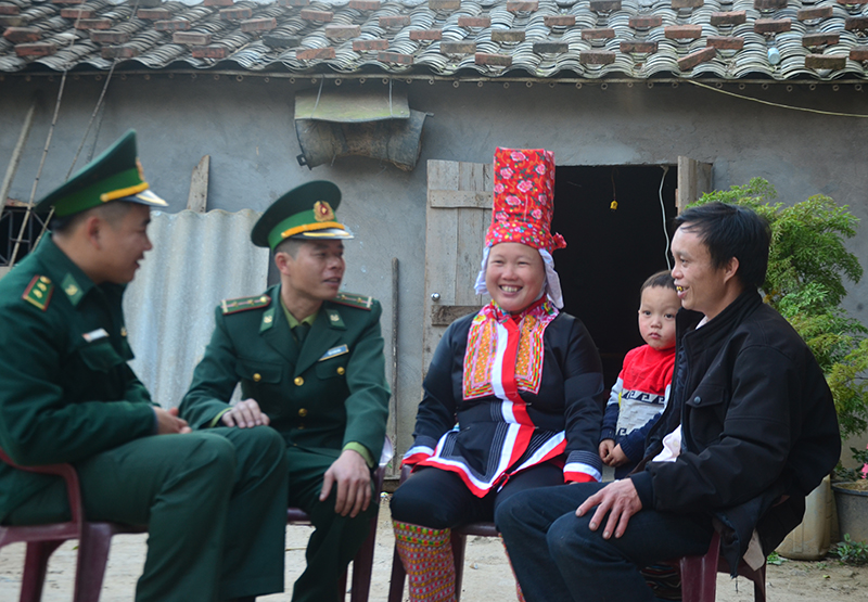 Chiến sĩ Đồn Biên phòng Cửa khẩu Hoành Mô trò chuyện với gia đình anh Chìu Dảu Thìn, hộ nghèo ở thôn Nà Dun, xã Hoành Mô.