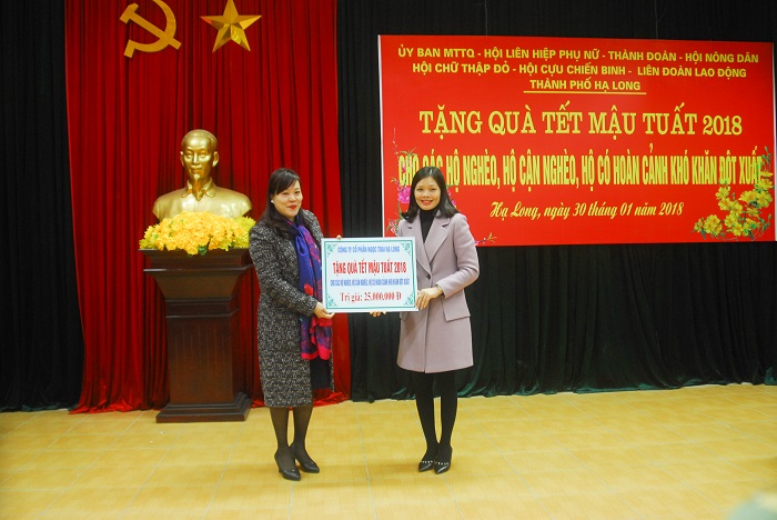 Đại diện Công ty CP Ngọc Trai - Hạ Long (bên trái) trao tặng 25 triệu đồng hỗ trợ các hộ nghèo của thành phố.