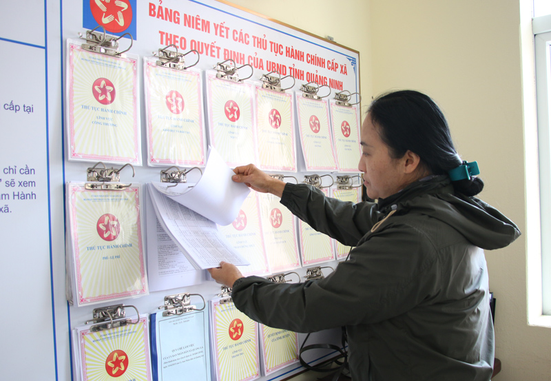 Người dân đọc các thủ tục niêm yết tại trụ sở UBND xã Quảng La, huyện Hoành Bồ.