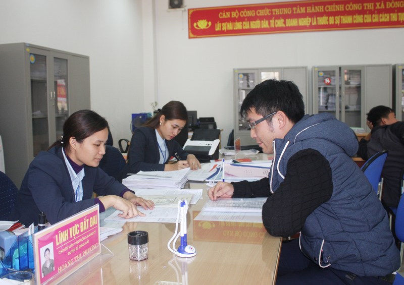 Cán bộ Trung tâm Hành chính công TX Đông Triều hướng dẫn công dân giải quyết thủ tục hành chính. Ảnh: Nguyễn Dung