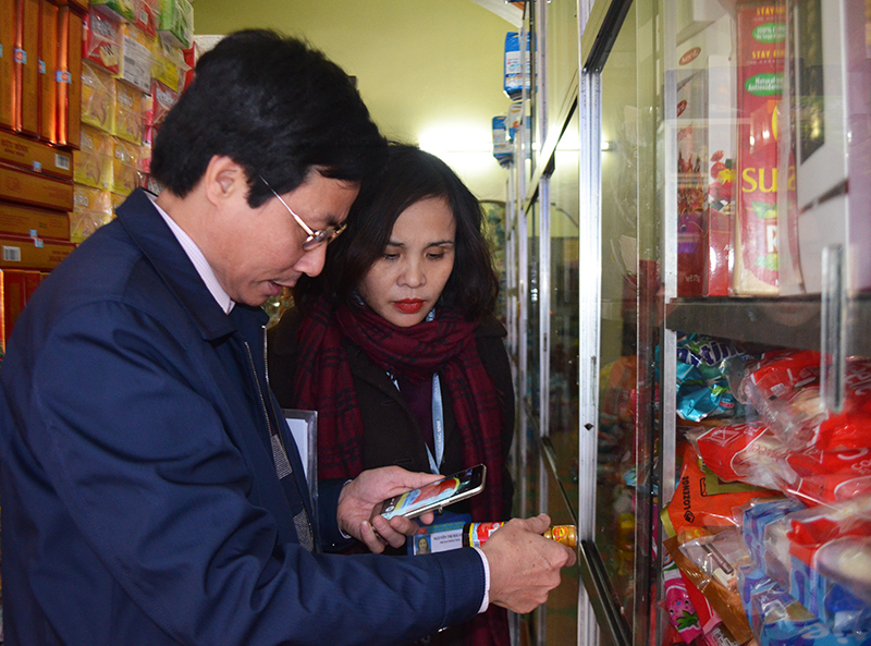 Thành viên đoàn kiểm tra sử dụng hần mềm Icheck để kiểm tra xuất xứ nguồn góc sản phẩm hàng hóa tại một điểm bán bánh kẹo trên địa bàn phường Đông Triều