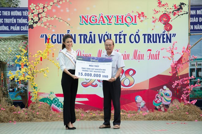 Á hậu Mâu Thủy ký tặng tạp chí cho các thế hệ đàn em của trường THPT Nguyễn Trãi. (Ảnh: BTC)