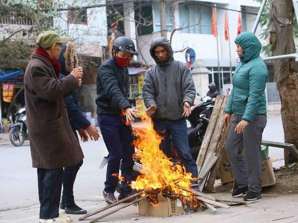 Người dân tại Hà Nội đốt củi để sưởi ấm tránh rét. (Ảnh: Quang Quyết/TTXVN)