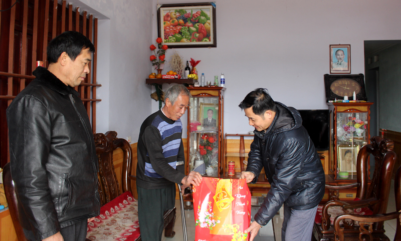 Đồng chí Nguyễn Hải Lý, Phó Bí thư Thường trực Huyện ủy tặng quà cho ông Châu Văn Mạnh, thương binh tại thôn Thái Hòa, xã Quan Lạn