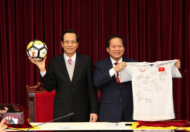 Bộ trưởng LĐTB&XH Đào Ngọc Dung (trái) và Bộ trưởng Bộ TT&TT Trương Minh Tuấn giới thiệu quả bóng và áo đấu có đầy đủ chữ ký các thành viên Đội tuyển U23 Việt Nam tặng Thủ tướng, và Thủ tướng tặng lại để đấu giá làm từ thiện - Ảnh: ĐẶNG DŨNG