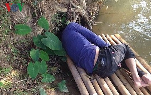 Người đàn ông lạ được phát  hiện bất tỉnh trên chiếc bè nứa bên sông (Ảnh: Hùng Cường).