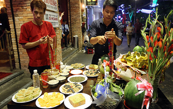 Người Việt Nam thờ cúng, ngắm pháo hoa Các cửa hàng ở trung tâm quận 1 thành phố Hồ Chí Minh chuẩn bị mâm cúng giao thừa. Ảnh: Quỳnh Trần.