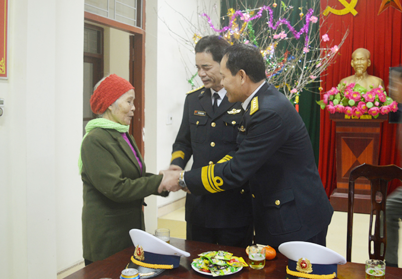 Cụ Lý Thị Dung, đảo Trà Bản, huyện Vân Đồn chia sẻ tình cảm cùng các lãnh đạo Bộ Tư lệnh vùng 1 Hải quân. 