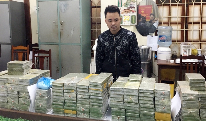 Đối tượng Trần Văn Thành và số lượng 288 bánh heroin thu giữ. Ảnh CAND