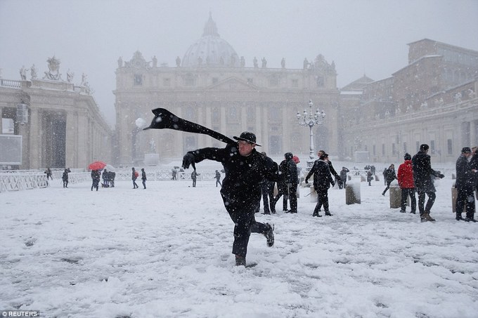 Một thầy tu trẻ chơi ném bóng tuyết tại quảng trường St. Peter's cùng những du khách từ khắp nơi trên thế giới. Ảnh: Reuters.