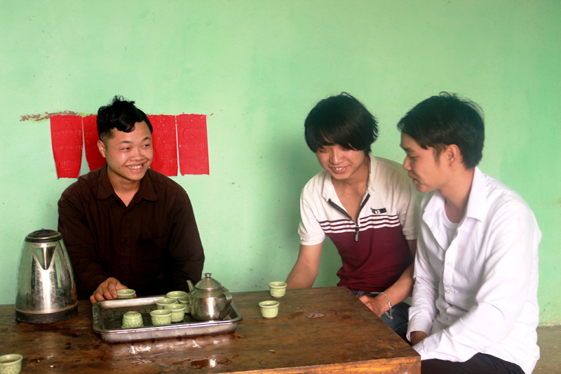 anh Thoòng (áo trắng bên phải) tuyên truyền, vận động bà con trong thôn phát triển kinh tế 